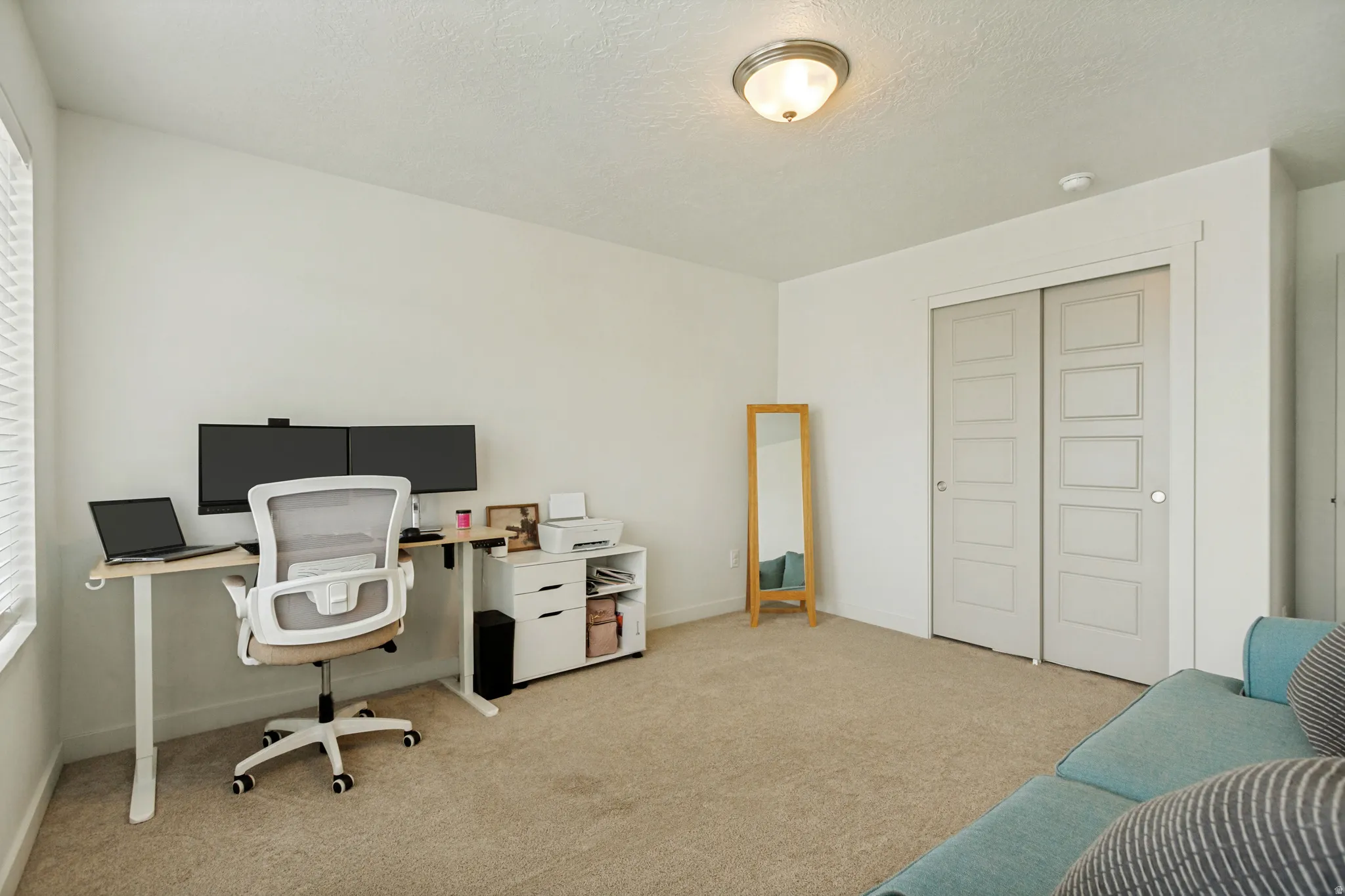 Carpeted flooring, white walls, and a ceiling-mounted light fixture