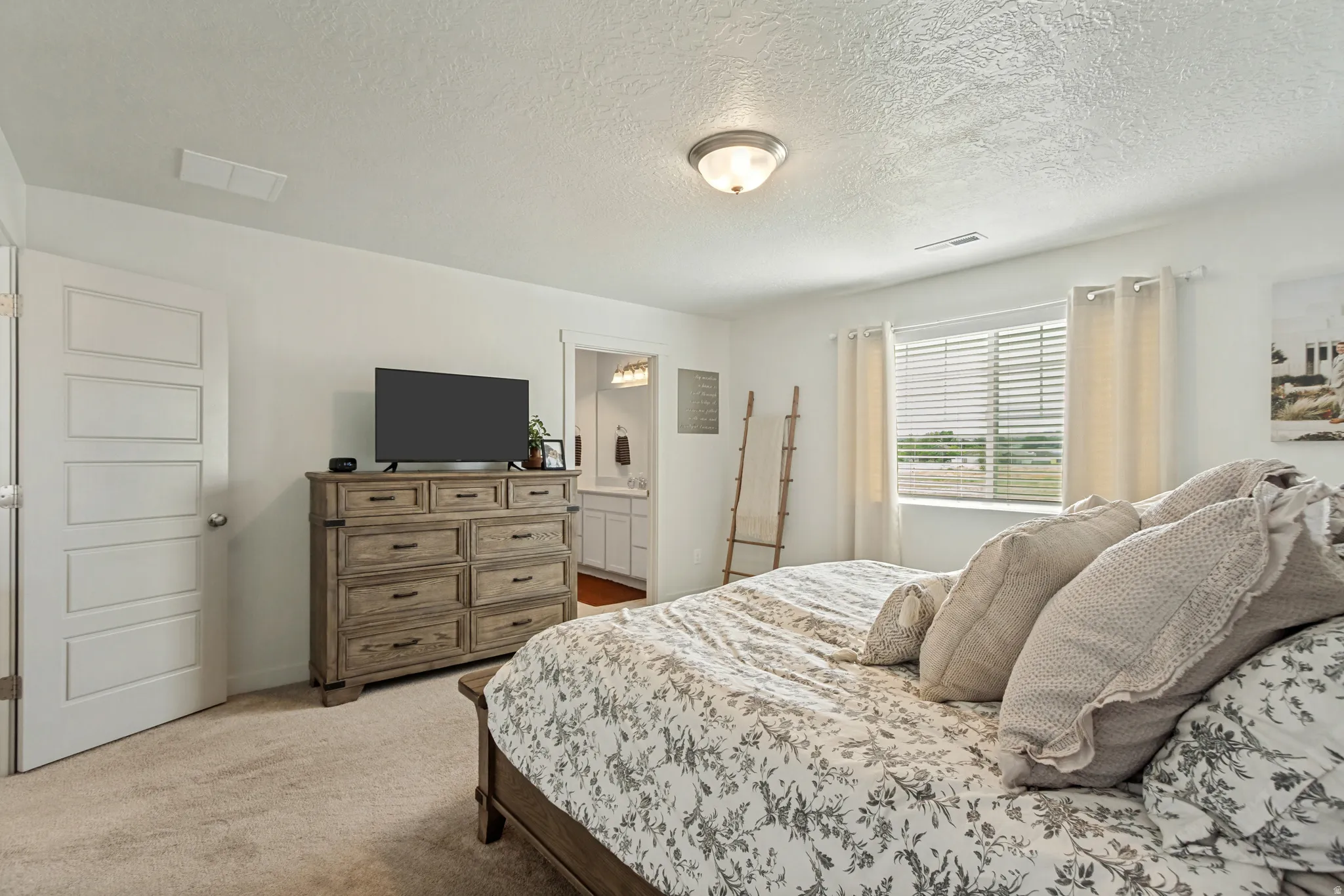 Carpeted flooring, white walls, five-panel interior door, and an overhead light fixture