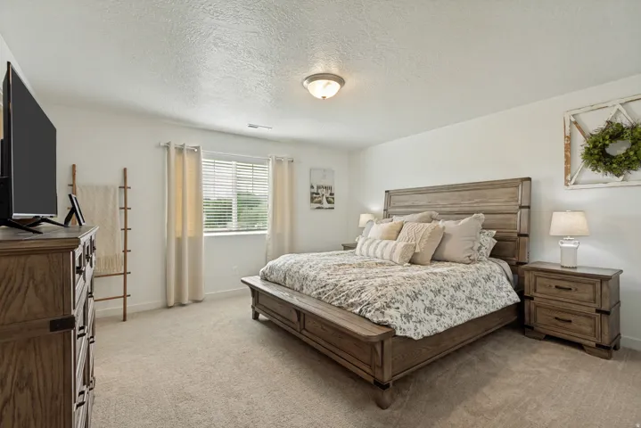 Neutral wall color, window with blinds, carpeted flooring, and a ceiling-mounted light fixture
