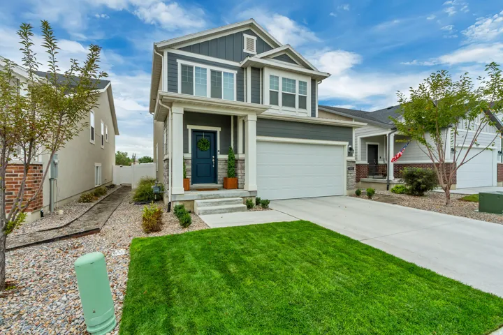 Two-story residence featuring a dark blue entry door, an attached two-car garage, and a concrete driveway