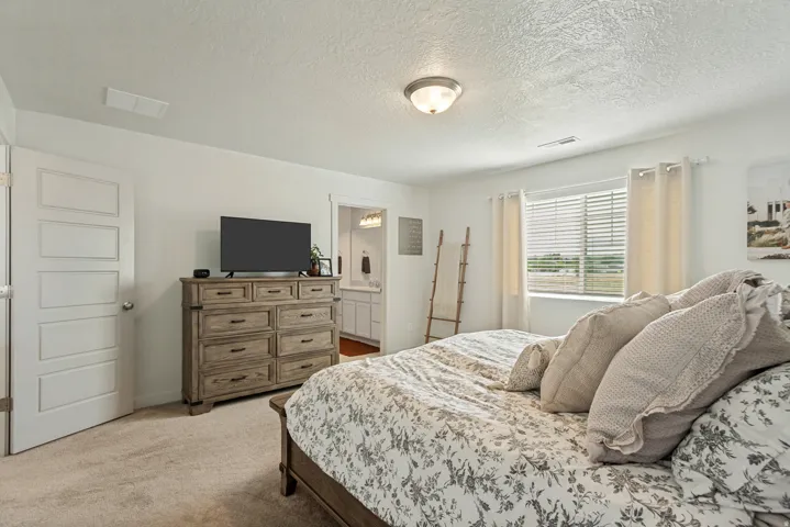 Carpeted flooring, white walls, five-panel interior door, and an overhead light fixture