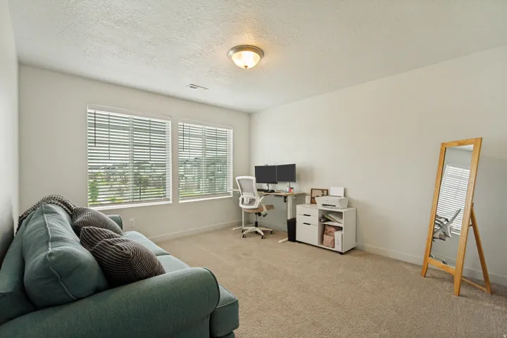 Bright and airy bonus room with abundant natural light from dual large windows featuring plantation shutters, neutral carpet flooring, and recessed ceiling lighting