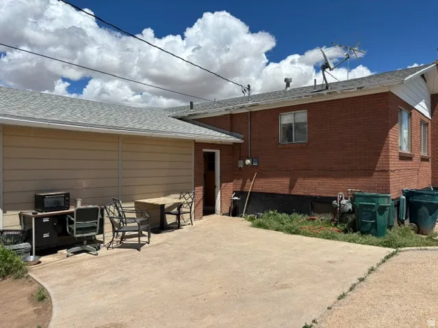 Brick exterior with an attached garage featuring horizontal siding and a shingled roof