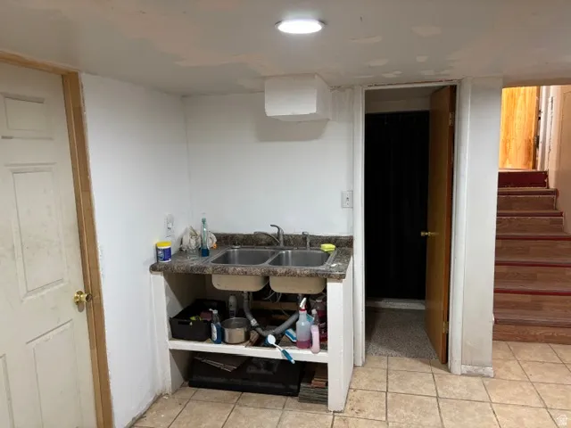 Tile flooring, double basin sink, laminate countertop, recessed ceiling lighting, and interior doorway
