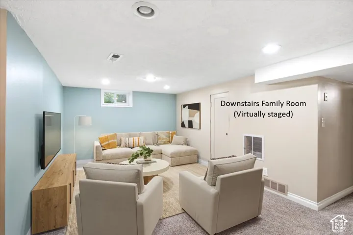 Recessed lighting, wood-finish media console, and light-toned carpeting