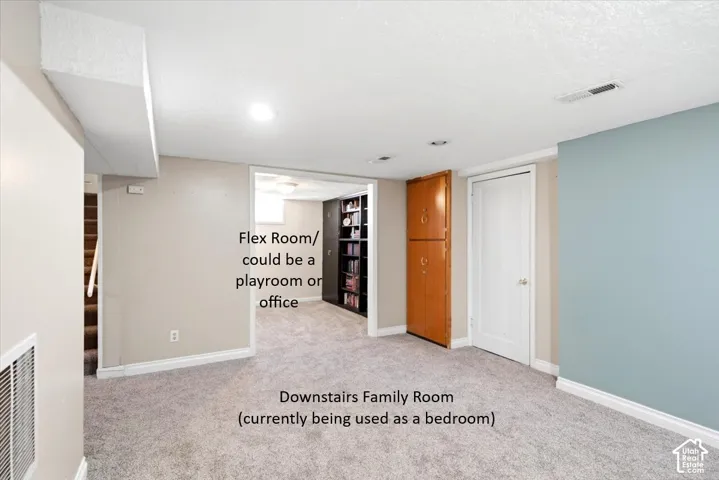 Carpeted recreational room with recessed lighting, a built-in storage cabinet, and a dedicated alcove
