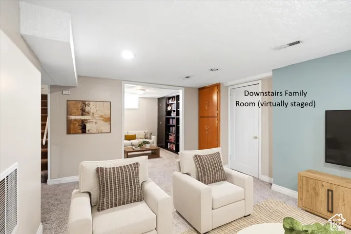 Recessed lighting, wood-finish built-in storage, light-toned carpeting, neutral wall paint, and a painted accent wall