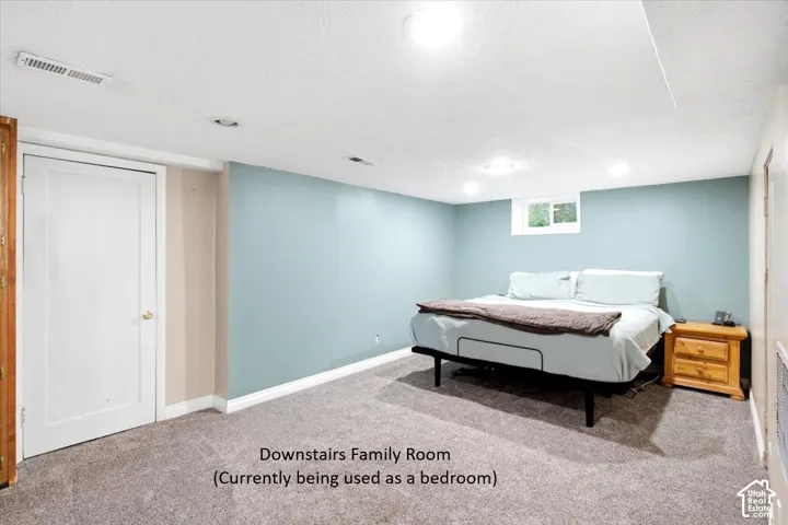 Carpeted room with recessed lighting and a window