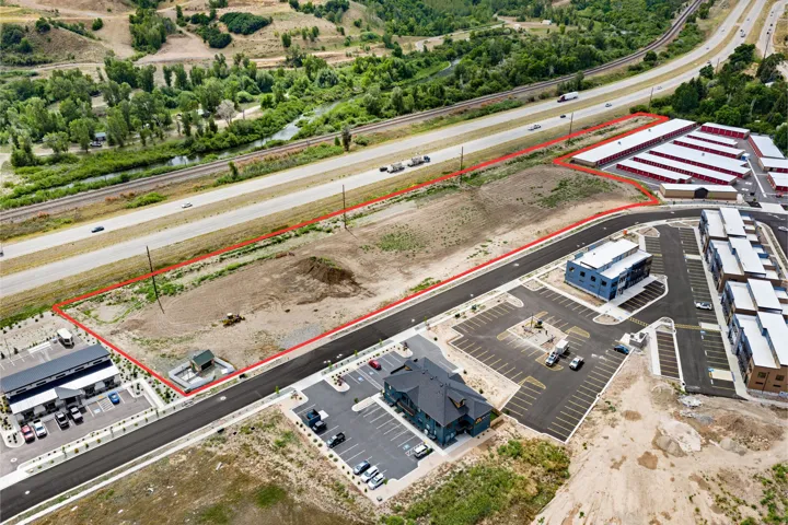 Expansive land parcel outlined in red, featuring direct road frontage and visible proximity to a highway