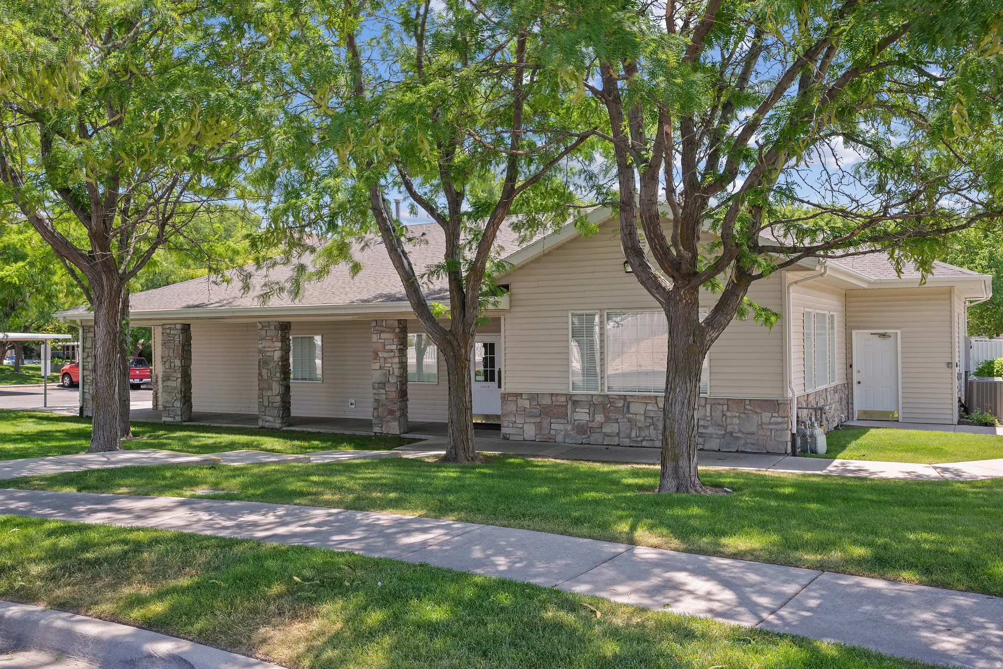 Single-story exterior with light-colored siding and stone veneer accents