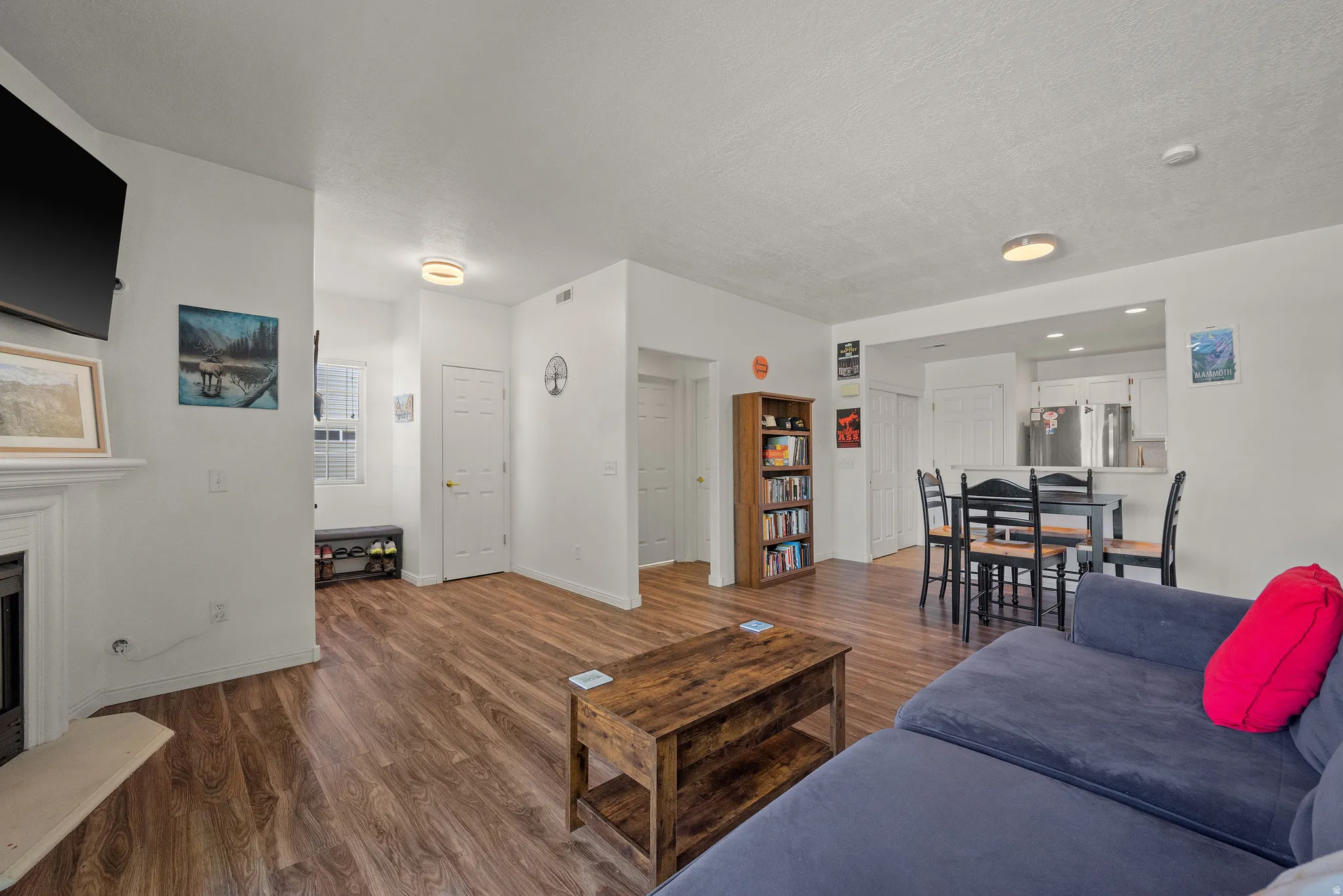 Living area with wood-finish flooring, white walls, and recessed lighting
