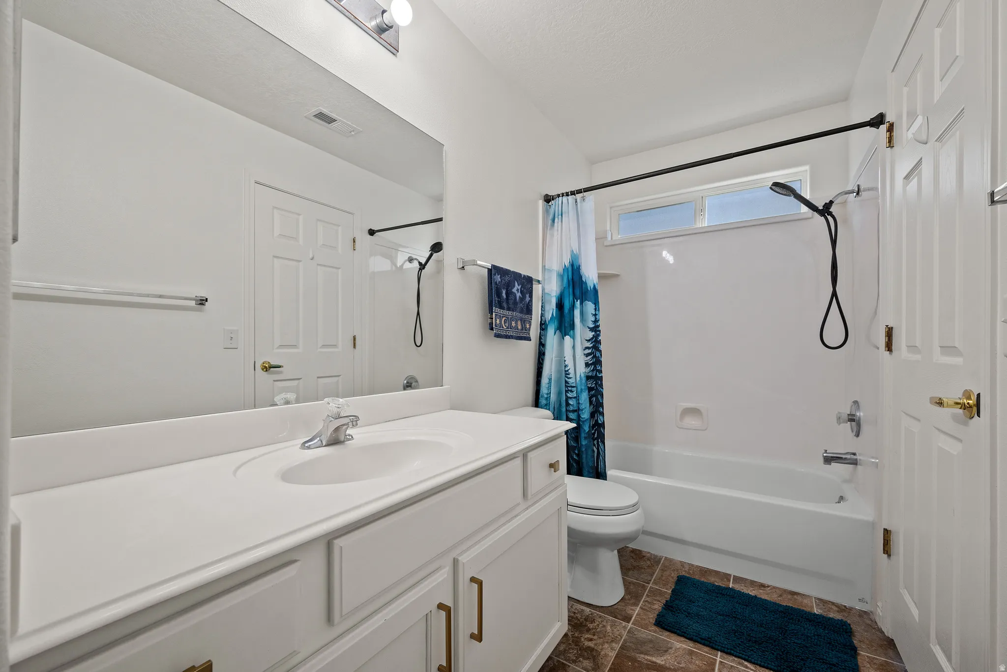 White vanity with integrated sink, chrome faucet, and bronze hardware