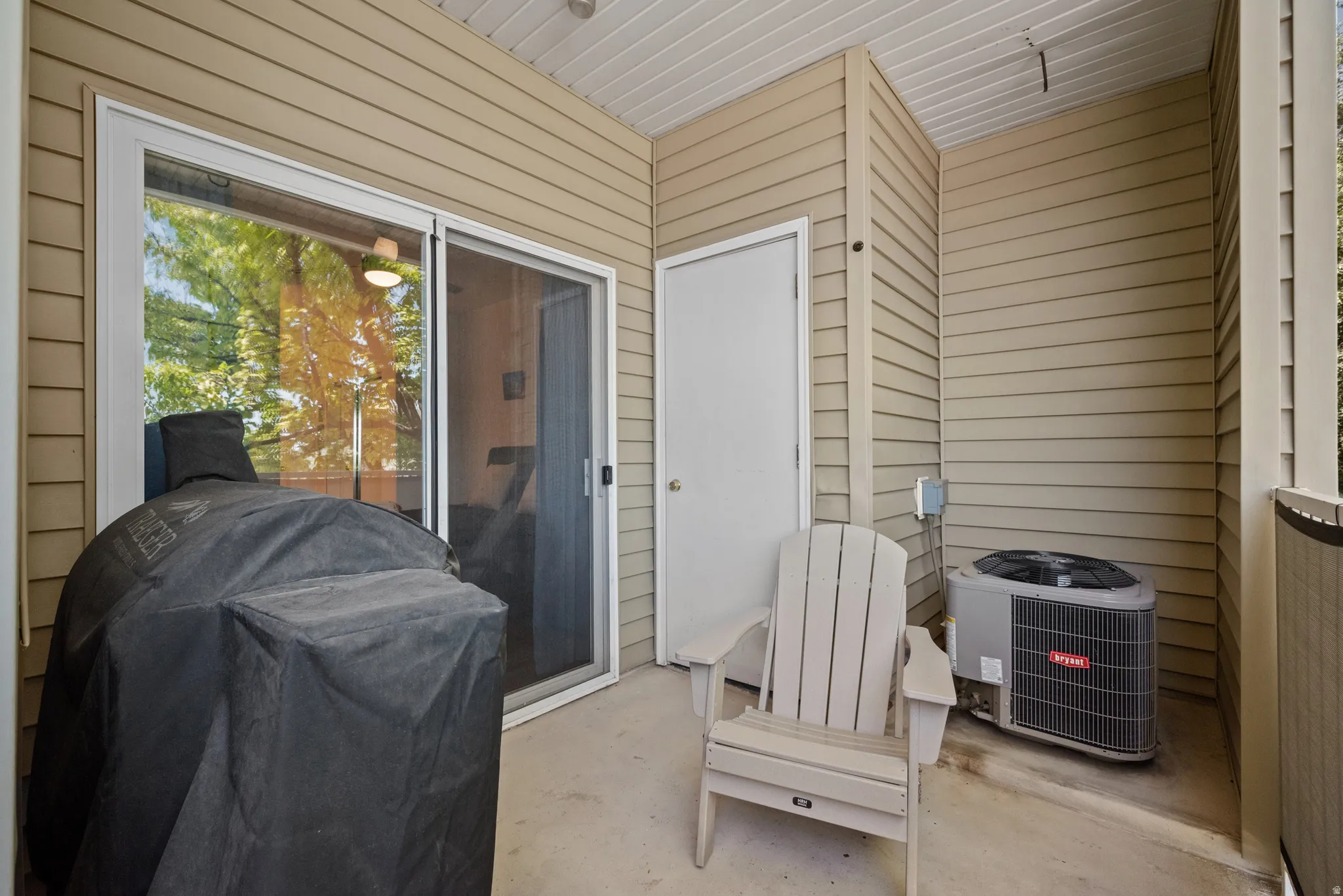 Outdoor patio featuring a sliding glass door and durable siding