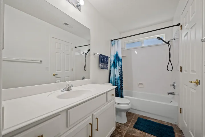 White vanity with integrated sink, chrome faucet, and bronze hardware