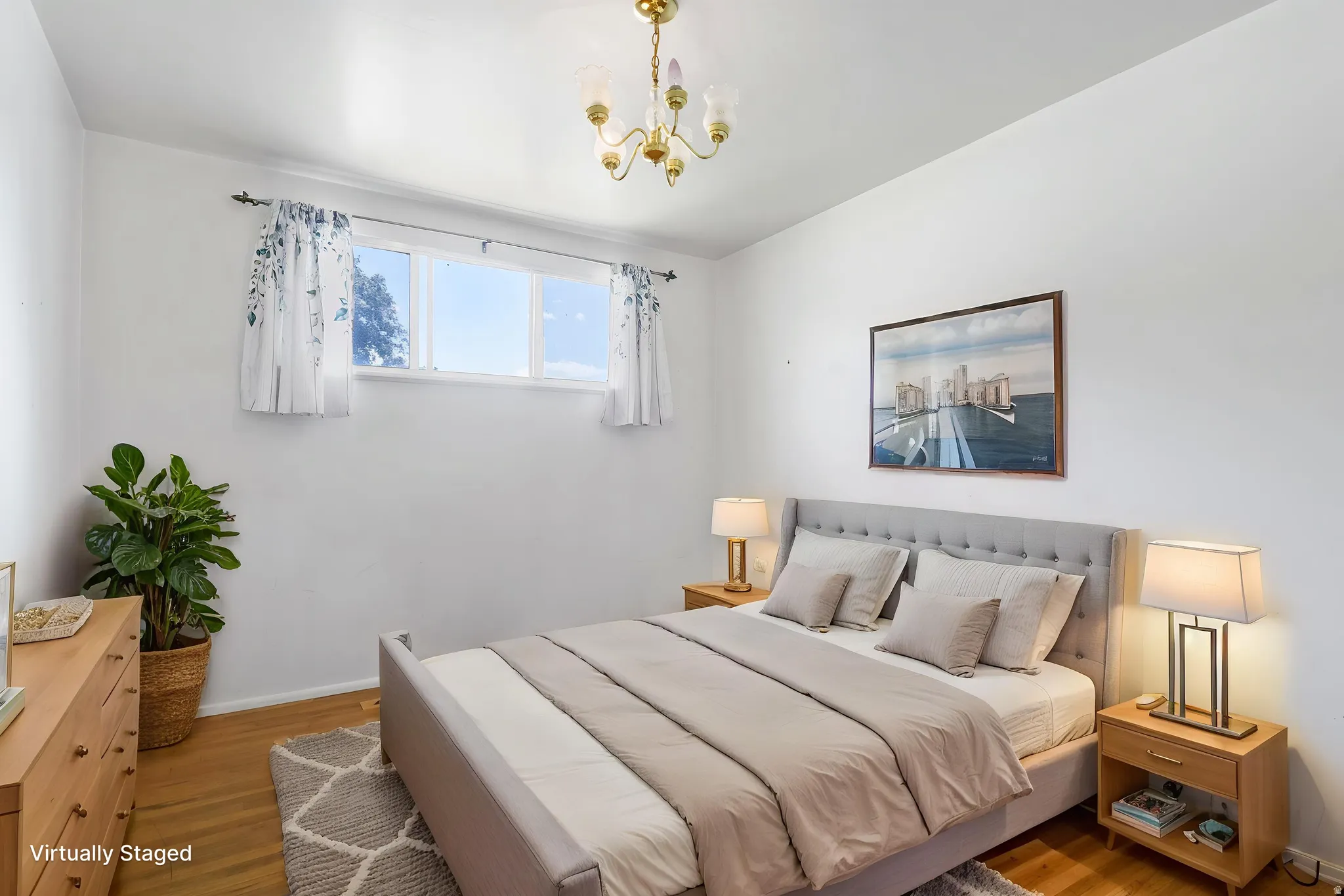 Light-filled room featuring a multi-pane window, wood-finish flooring, and a ceiling-mounted light fixture