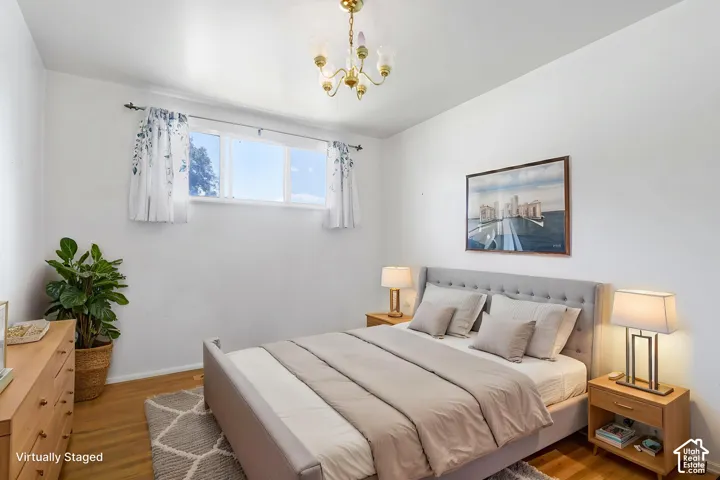 Light-filled room featuring a multi-pane window, wood-finish flooring, and a ceiling-mounted light fixture