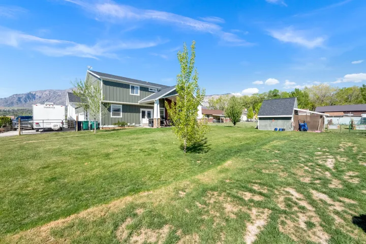 Expansive backyard with a detached shed, bordered by a wood fence