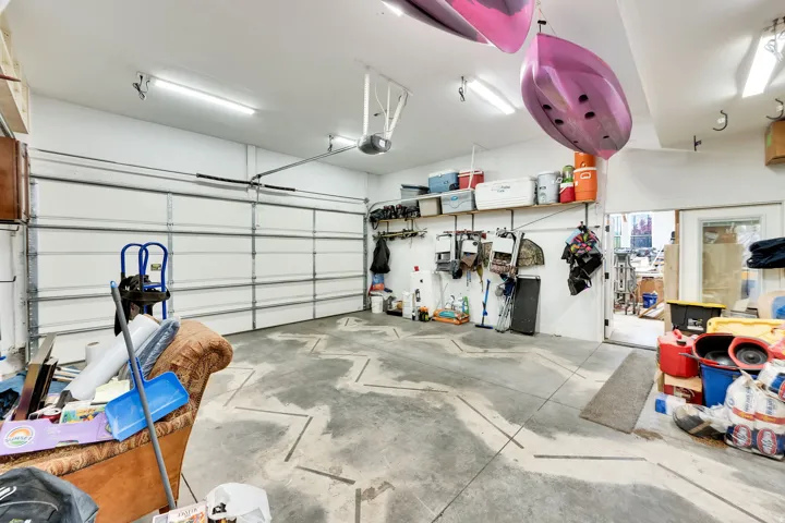 Garage space with concrete flooring, overhead lighting, and an automatic garage door opener