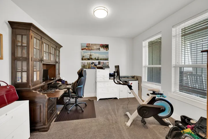 Recessed ceiling lighting, multiple windows with blinds, and neutral wall tones