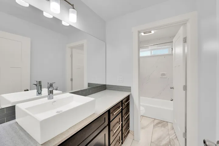 Modern vanity with a rectangular vessel sink, polished chrome faucet, and dark wood-finish cabinetry