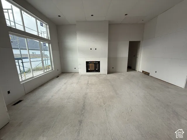 Expansive interior with a floor-to-ceiling fireplace, large windows, and recessed lighting