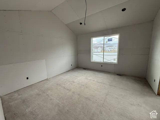 Primary Bedroom featuring Vaulted ceiling with recessed lighting, large window with mountain scenery, and concrete subfloor