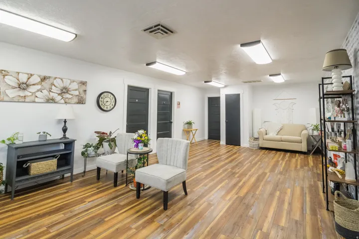Wood-finish flooring, white walls, and multiple built-in doors