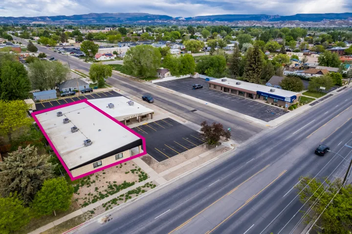Commercial building with a flat roof, prominent street frontage, and an adjacent paved parking area