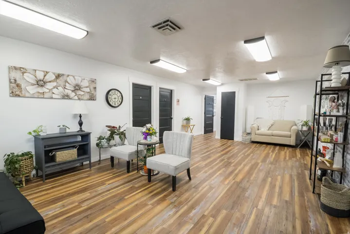 Spacious interior featuring wood-finish flooring, white walls, and multiple flush-mount ceiling lights