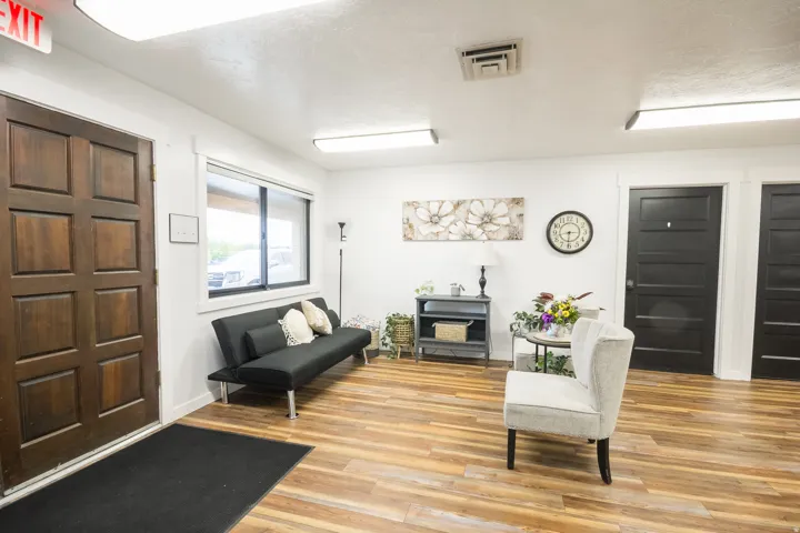 Wood-finish flooring, white walls, and dark wood panel doors