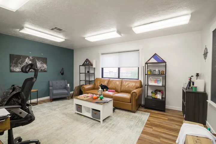 Recessed lighting, wood-finish flooring, and a large window with roller shades