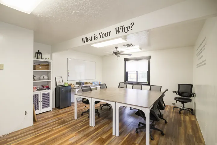 Wood-finish flooring, recessed lighting, ceiling fan, built-in shelving unit, and a window with blinds