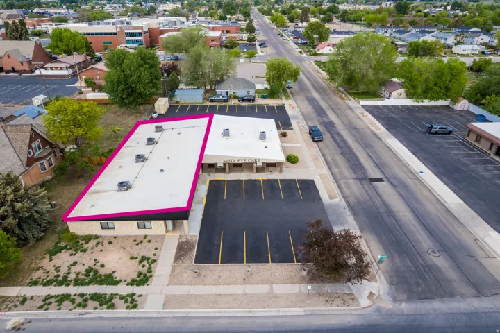 Commercial building featuring a flat roofline, multiple HVAC units, and a paved parking lot with marked spaces