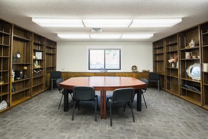 Built-in wood-finish shelving, recessed window, and patterned carpet