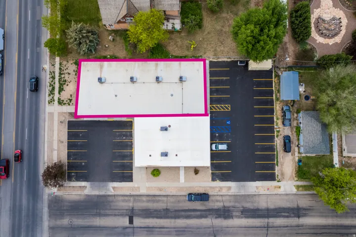 Paved parking area, accessible parking spaces, street frontage, commercial building, and adjacent building