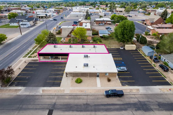 Commercial property with extensive paved parking, direct road frontage, and a flat roof structure