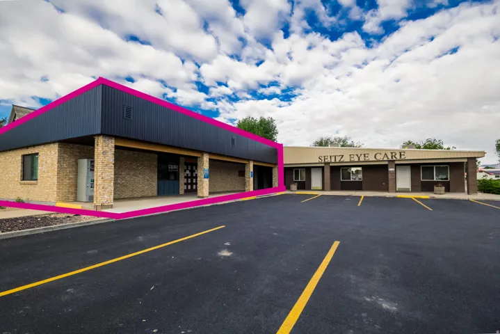 Commercial building featuring a brick facade, panel siding, and a covered entrance