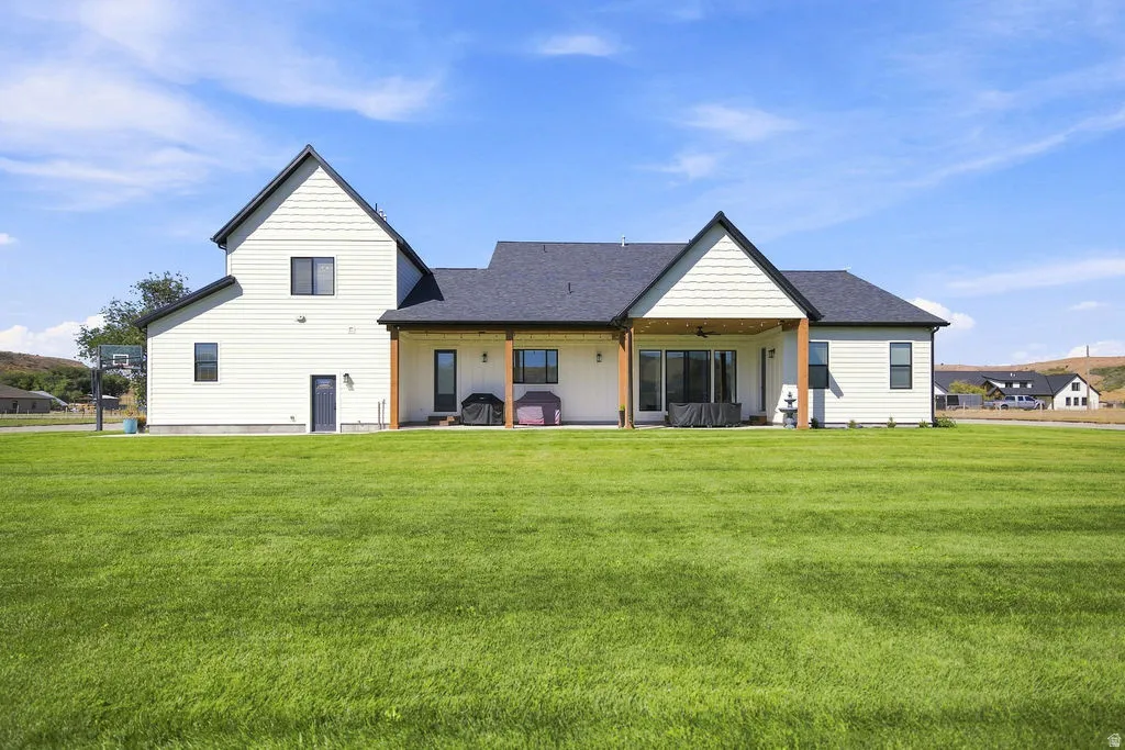 Expansive green lawn with a two-story residence featuring light-colored siding