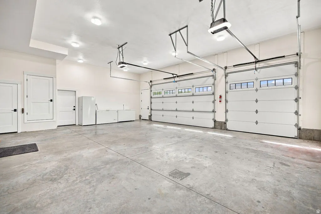 Spacious garage with multiple overhead doors, concrete flooring, and recessed ceiling lighting