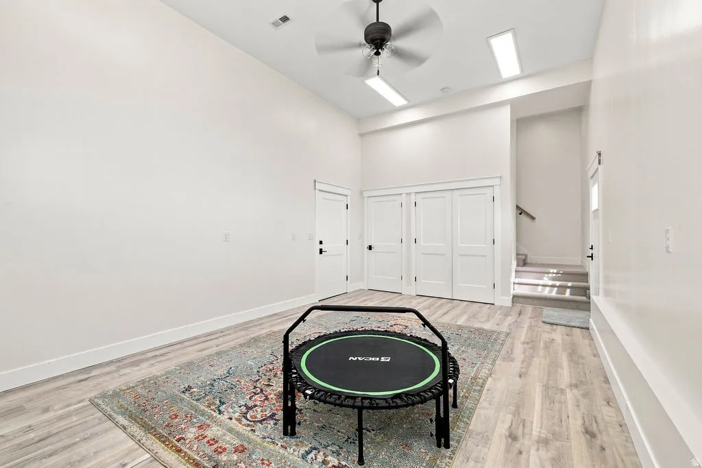 High ceilings, wood-finish flooring, ceiling fan, recessed lighting, and white panel doors