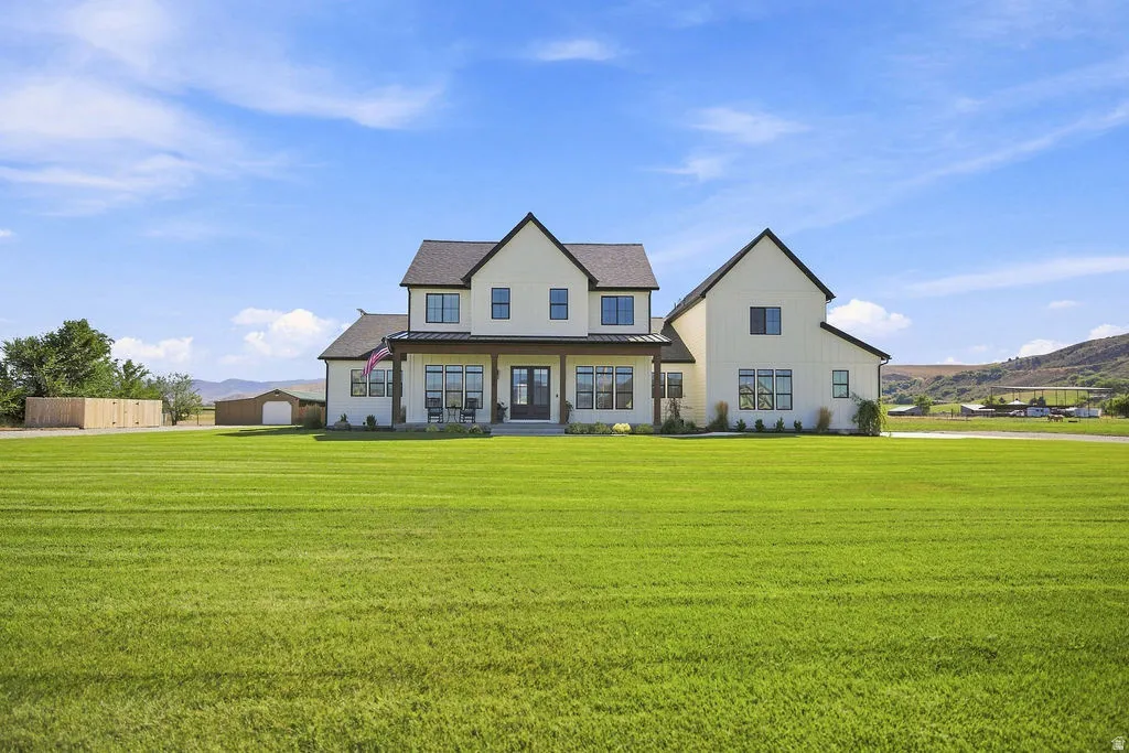 Two-story residence with a covered front porch featuring dark wood columns