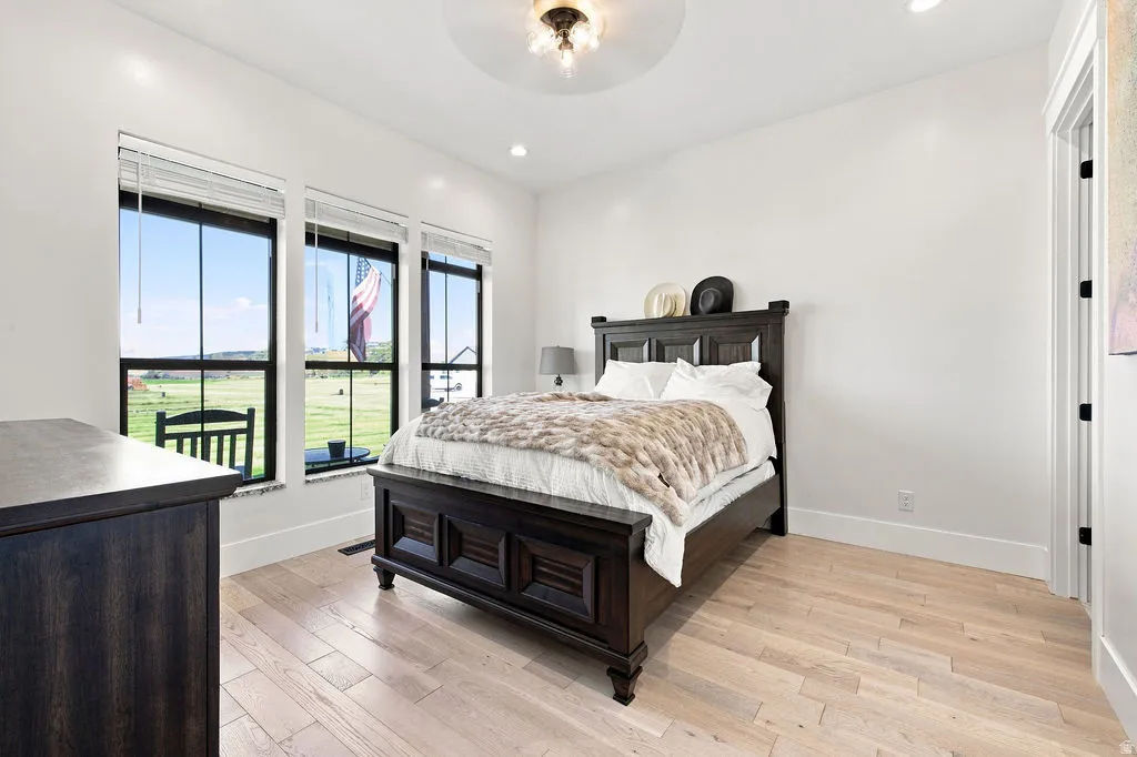 Light wood-finish flooring, recessed lighting, and multiple windows with dark frames