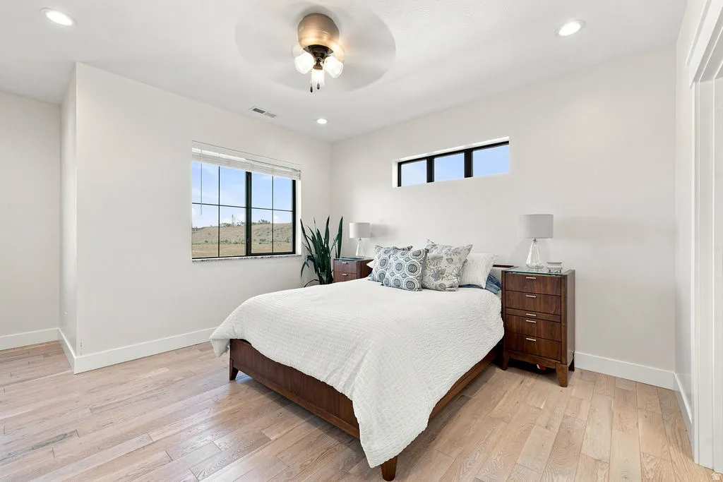 Hardwood flooring, recessed lighting, ceiling fan, large window, and high wall window