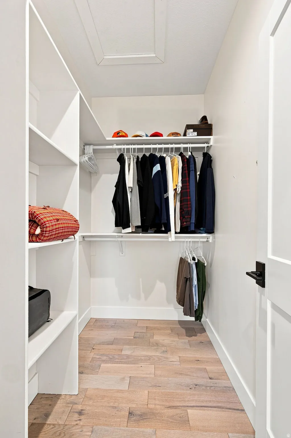 Custom built-in shelving, integrated hanging rods, and wood-finish flooring