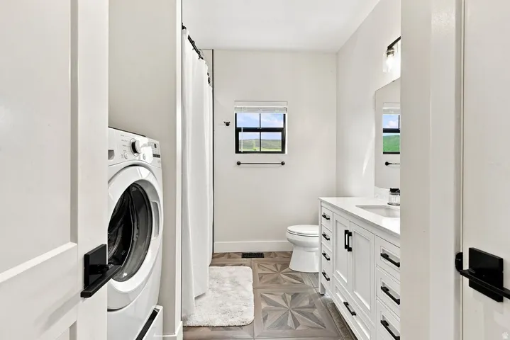 White vanity with a single basin, dark hardware, and a framed mirror