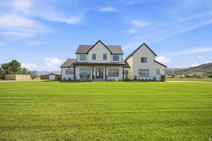 Two-story residence with a covered front porch featuring dark wood columns