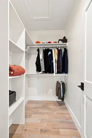 Custom built-in shelving, integrated hanging rods, and wood-finish flooring
