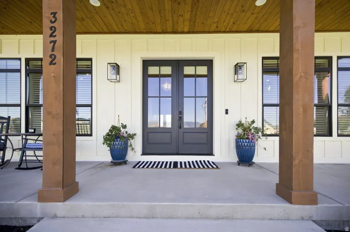 Board and batten exterior with a wood-finish porch ceiling and substantial wood pillars