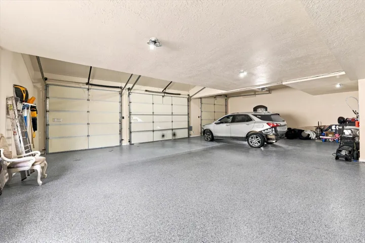 Spacious garage featuring two overhead doors and a durable speckled epoxy floor coating