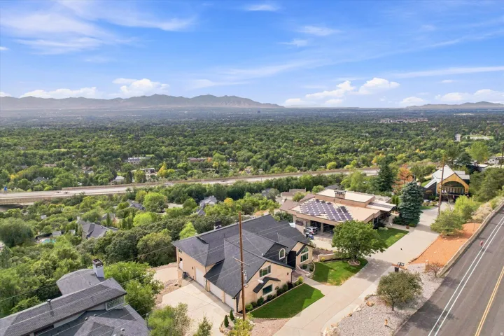 Two-story residential structure with an attached garage, paved driveway, and established landscaping